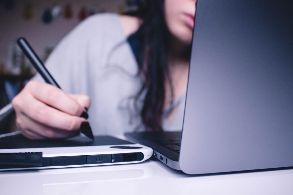 A lady working at her computer in deep thought