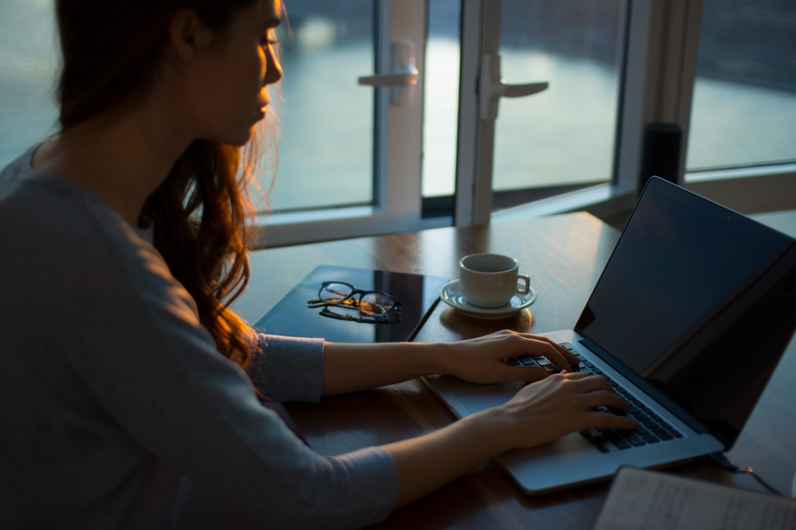 A woman is sitting in front of her computer looking stressed.