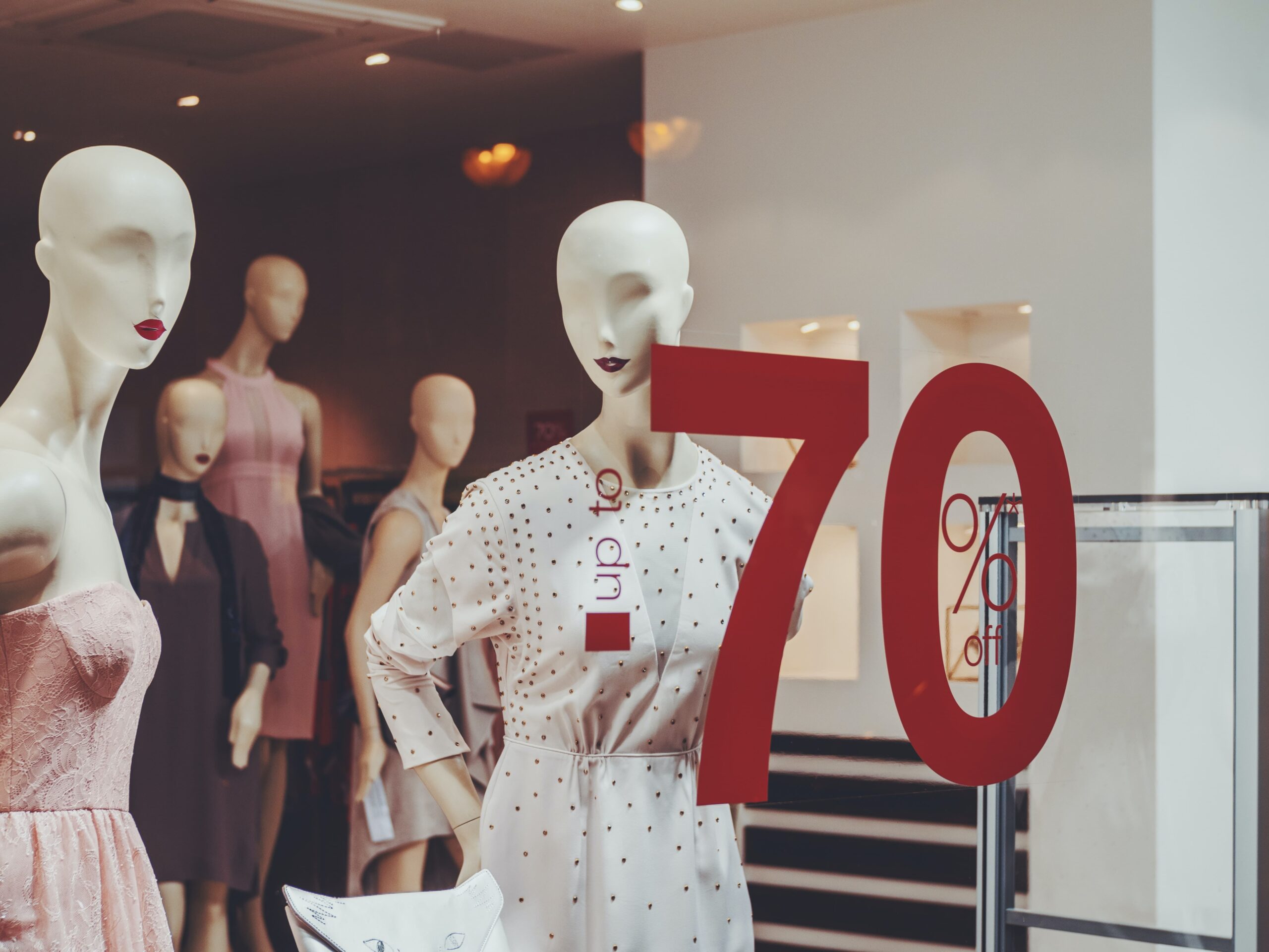 Manequins at a store with a special sign on the front window